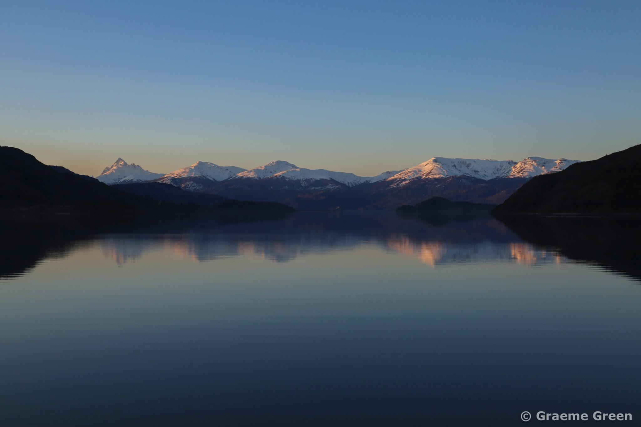 Early morning light hitting the snow-covered mountains in Aysen in Patagonia, Chile.